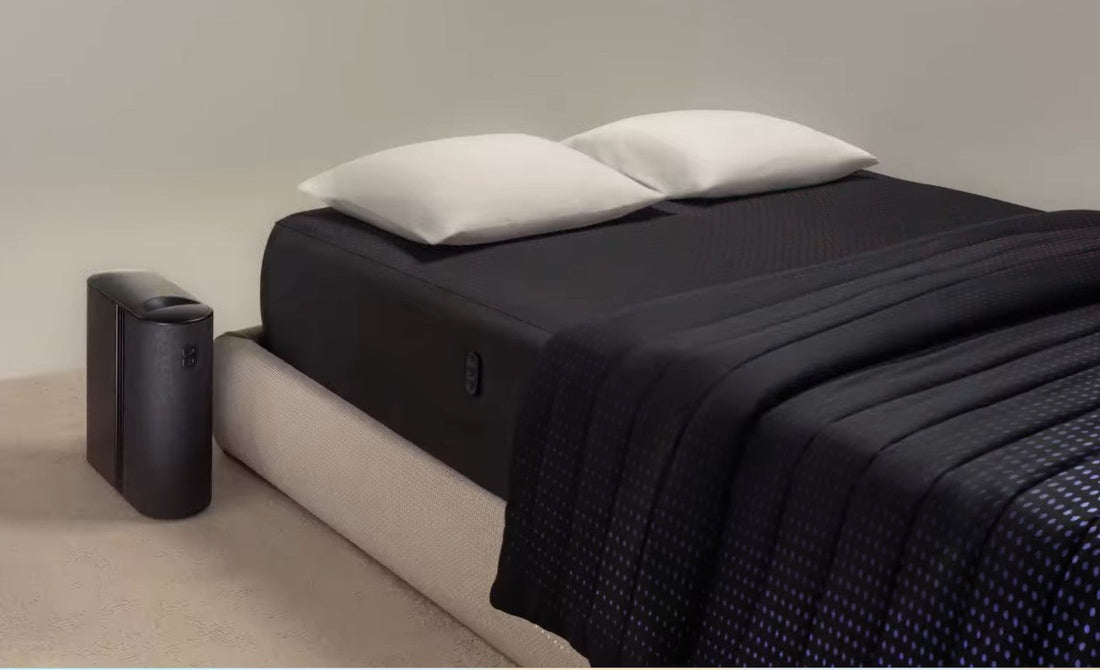 A sleek, modern bed with a mattress and pillows beside a black air purifier on the floor