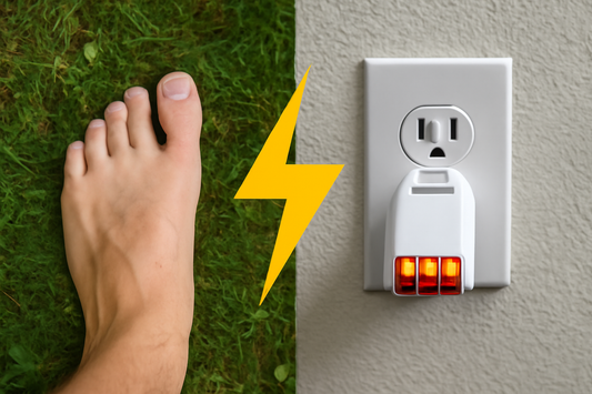 Bare foot on grass with electrical outlet tester showing orange lights and a lightning bolt