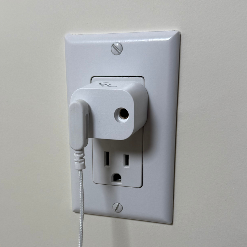 Groundluxe grounding safety adapter plugged into a grounded wall outlet with the grounding cord plugged into it.