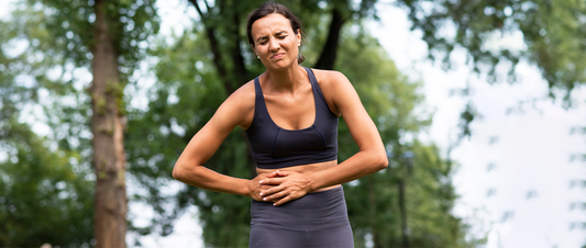 woman holding her stomach in discomfort