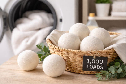 Wool dryer balls in a wicker basket beside a dryer in a clean, bright laundry room setting.