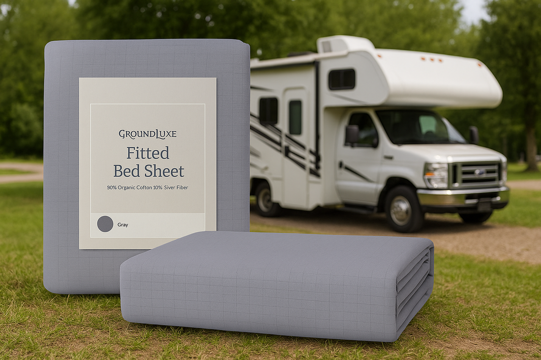 Gray GroundLuxe fitted bed sheet beside an RV on grass with forest background, captured in daylight.