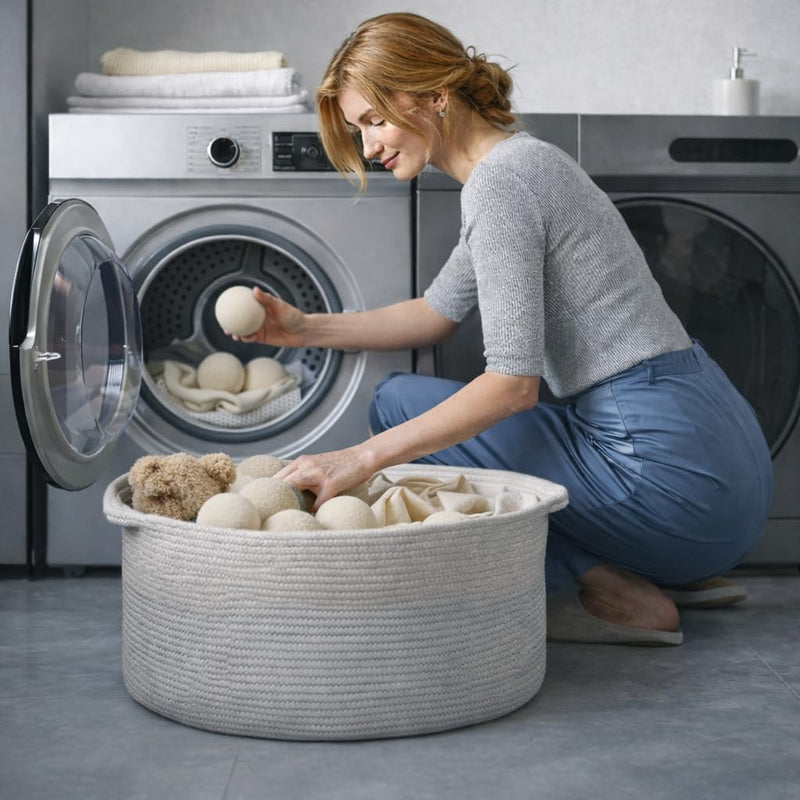Woman sorting laundry in a basket with washing machines in the background

