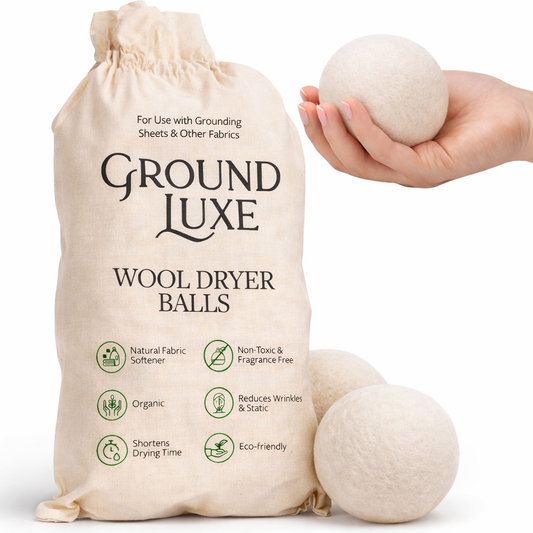 Ground Luxe wool dryer balls with packaging and a hand holding a ball.


