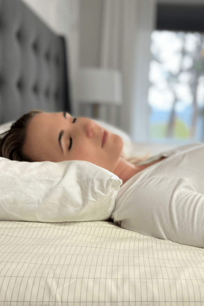Woman sleeping using grounding sheets for menopause and hot flashes