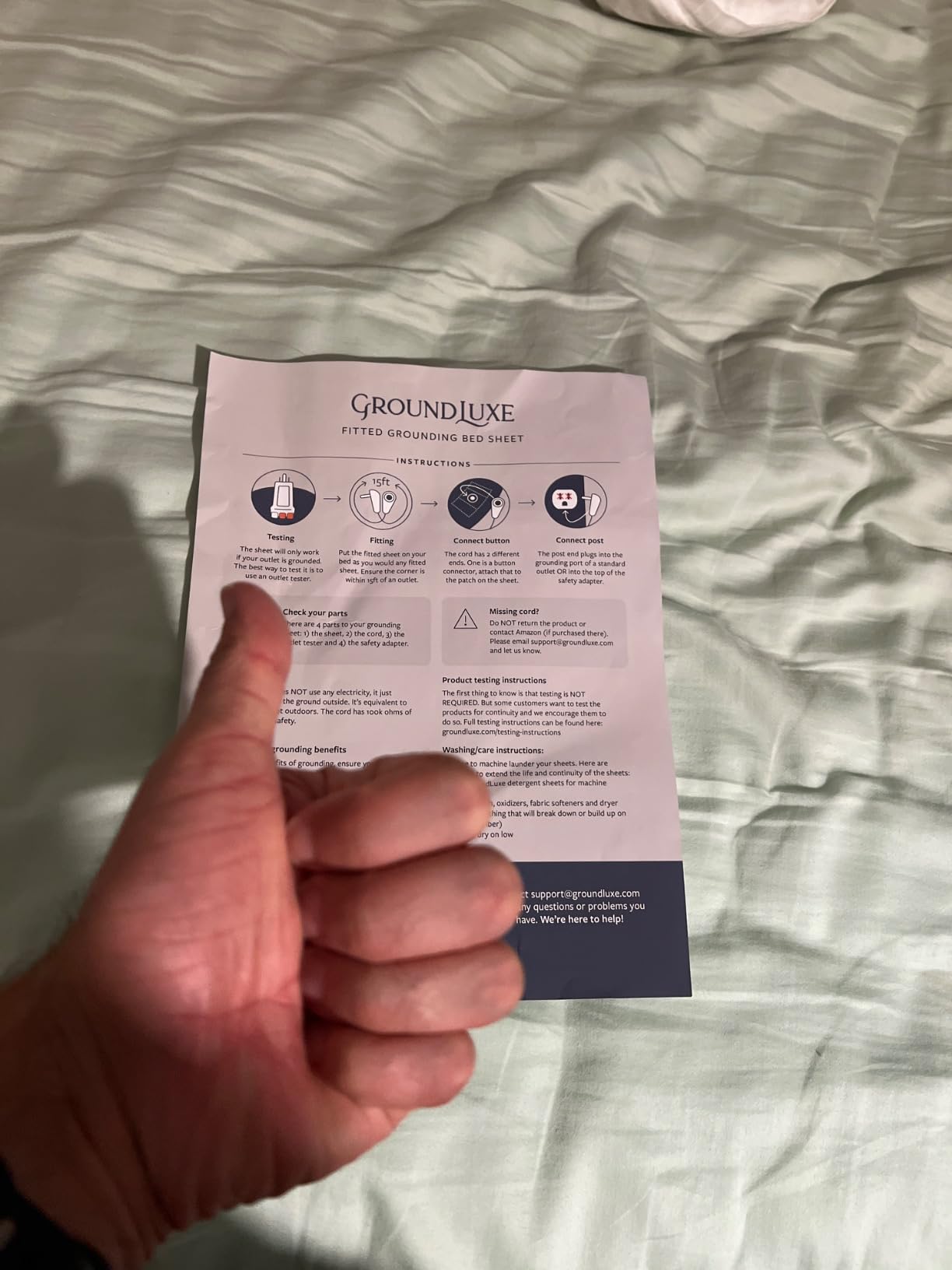 Verified customer holding GroundLuxe grounding sheet insert for menopause relief