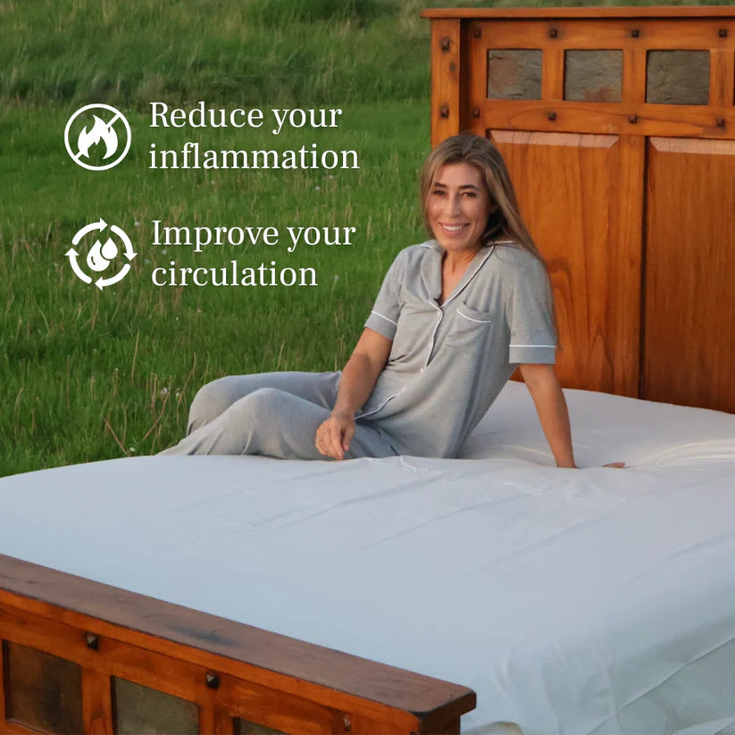 Woman sitting on grounding bed sheet outdoors, with benefits listed: reduce inflammation and improve circulation