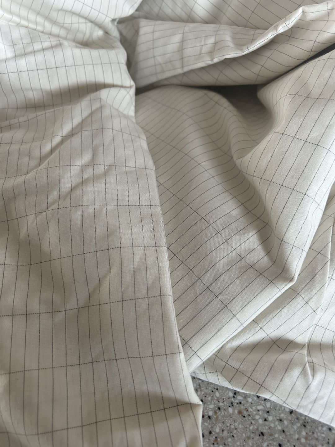 Close-up of organic grounding sheet fabric with silver thread grid pattern