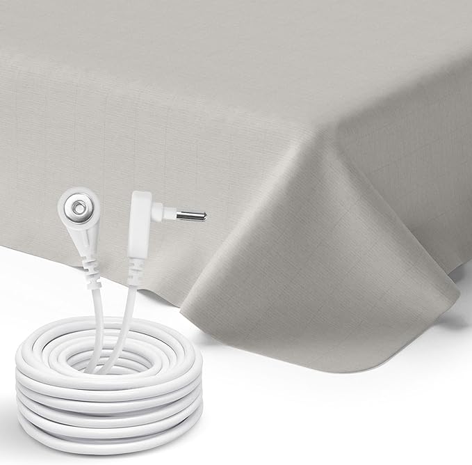 Beige GroundLuxe flat grounding sheet spread across a queen-size bed.